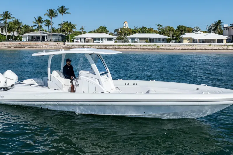  Yacht Photos Pics 2025 Airship 340 boat cruising near a tropical shoreline with palm trees.
