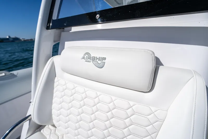  Yacht Photos Pics White leather seat on 2025 Airship 340 boat with embossed logo, ocean in background.