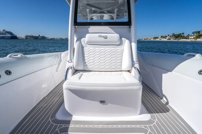  Yacht Photos Pics 2025 Airship 340 boat interior with white seating, on calm water, under clear blue sky.
