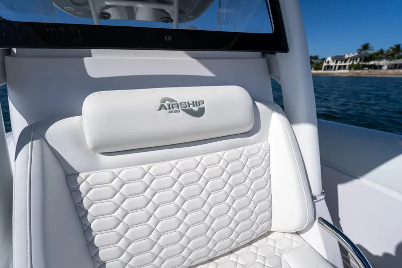  Yacht Photos Pics Luxurious white seat on 2025 Airship 340 boat, featuring hexagonal stitching and logo.