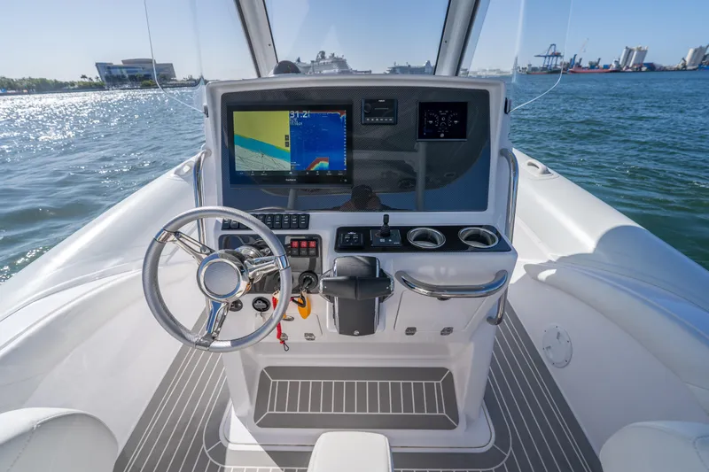  Yacht Photos Pics Cockpit of 2025 Airship 340 boat with steering wheel and navigation display on open water.