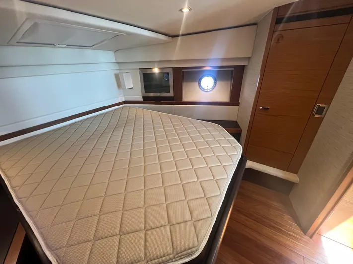 B.u.b. Yacht Photos Pics 2016 Tiara Yachts 44 Coupe bedroom with mattress, porthole, and wooden flooring.