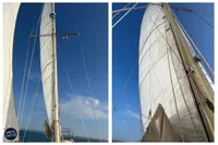 Sailing yacht BOUVIER/JOUFFRAY BILINGA 1976 with tall masts and sails against a clear blue sky.