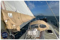 Sailing yacht BOUVIER/JOUFFRAY BILINGA 1976 on open sea, beige sail cover, clear sky.