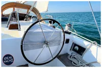 Sailboat cockpit view with steering wheel, ocean backdrop, BOUVIER/JOUFFRAY BILINGA 1976.