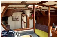Interior of 1976 BOUVIER/JOUFFRAY BILINGA yacht with wooden accents and cozy seating.