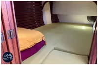 Cozy cabin interior of 1976 BOUVIER/JOUFFRAY BILINGA yacht with wooden accents and bedding.