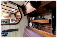 Interior of 1976 BOUVIER/JOUFFRAY BILINGA yacht with wooden shelves and cozy seating.