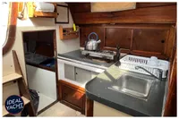 1976 BOUVIER JOUFFRAY BILINGA yacht kitchen with stove, sink, and wooden cabinetry.