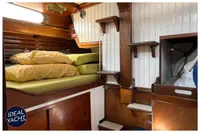 Cozy 1976 BOUVIER/JOUFFRAY BILINGA yacht cabin with wooden interior and bunk bed.
