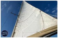 Sail of 1976 BOUVIER/JOUFFRAY BILINGA yacht against a clear blue sky.