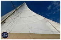 Sail of 1976 BOUVIER/JOUFFRAY BILINGA yacht against clear blue sky.