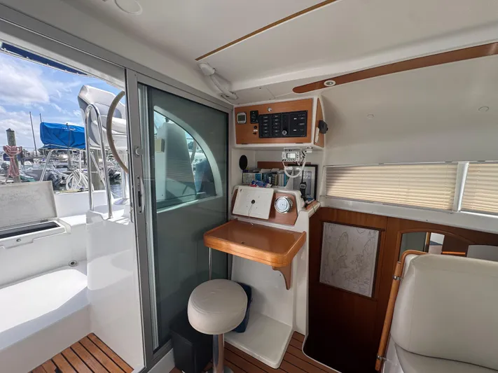Wylicat Yacht Photos Pics Interior of 2000 Lagoon 380 catamaran with navigation station and marina view.