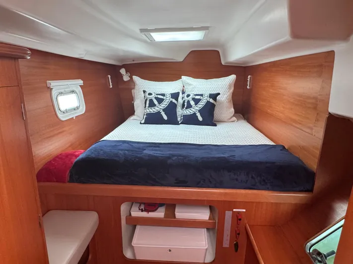 Wylicat Yacht Photos Pics Cozy cabin interior of 2000 Lagoon 380 catamaran with nautical-themed bedding.