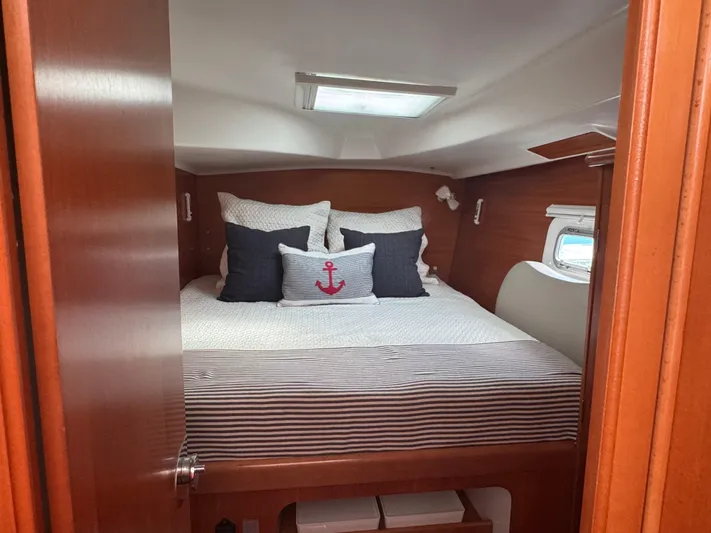 Wylicat Yacht Photos Pics Cozy cabin interior of 2000 Lagoon 380 catamaran with nautical-themed bedding.