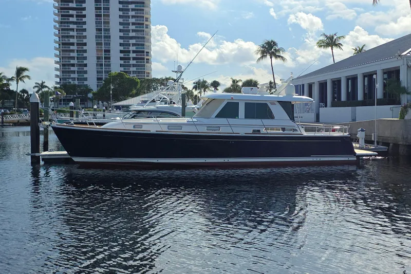 Vertical Yacht Photos Pics 2017 Sabre 48 Salon Express yacht docked near waterfront buildings and palm trees.