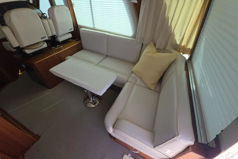 Vertical Yacht Photos Pics Interior of 2017 Sabre 48 Salon Express with white leather seating and table.