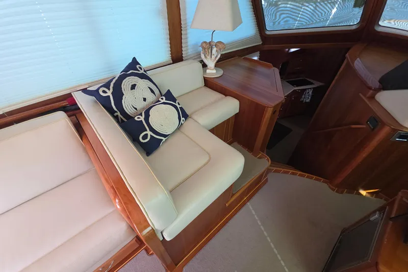 Vertical Yacht Photos Pics Interior of 2017 Sabre 48 Salon Express with nautical-themed cushions and wooden furnishings.