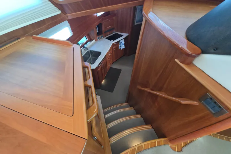 Vertical Yacht Photos Pics Interior view of 2017 Sabre 48 Salon Express yacht with wooden stairs and kitchen area.