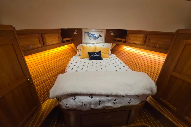Vertical Yacht Photos Pics Luxurious cabin interior of 2017 Sabre 48 Salon Express with cozy bedding and warm lighting.