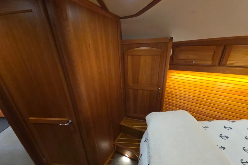 Vertical Yacht Photos Pics Interior of 2017 Sabre 48 Salon Express, featuring wooden paneling and cozy lighting.