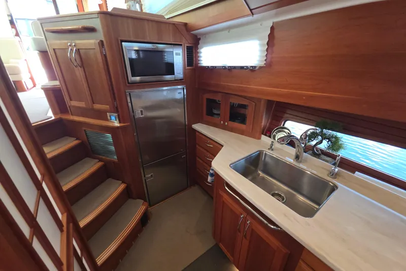 Vertical Yacht Photos Pics Luxurious 2017 Sabre 48 Salon Express yacht kitchen with wood cabinetry and stainless steel appliances.