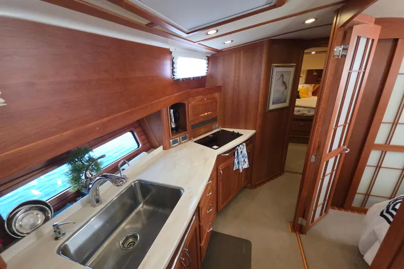 Vertical Yacht Photos Pics 2017 Sabre 48 Salon Express yacht interior with modern kitchen and wooden cabinetry.