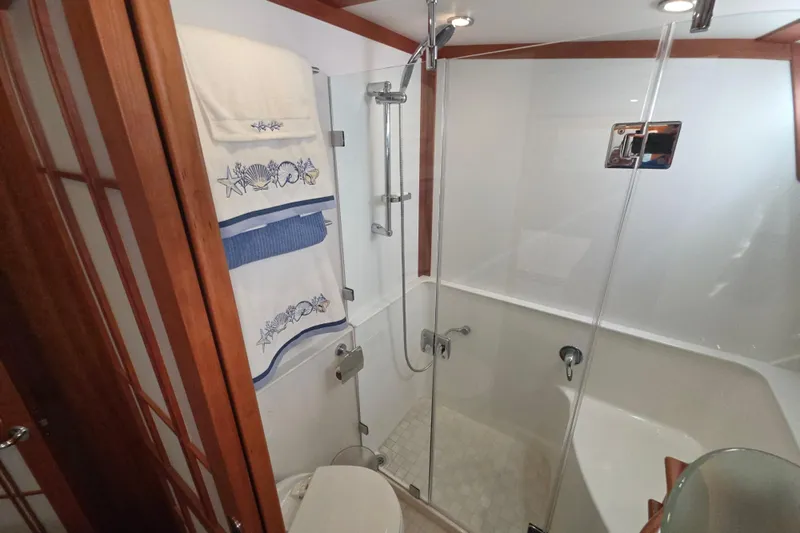 Vertical Yacht Photos Pics Bathroom interior of 2017 Sabre 48 Salon Express yacht with glass shower and decorative towels.