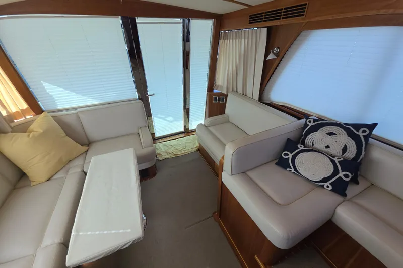 Vertical Yacht Photos Pics Interior of 2017 Sabre 48 Salon Express with elegant seating and nautical-themed cushions.