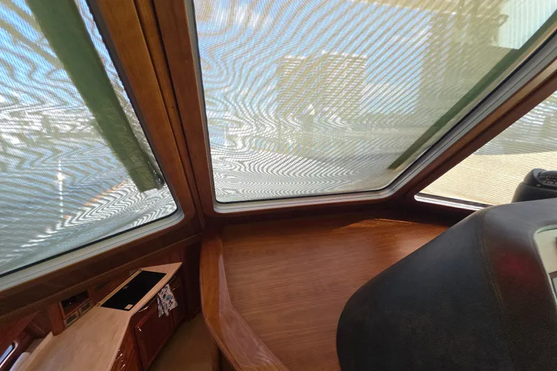 Vertical Yacht Photos Pics Interior view of 2017 Sabre 48 Salon Express with wooden finishes and large windows.