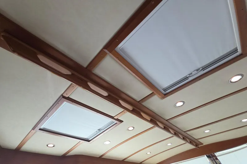 Vertical Yacht Photos Pics Ceiling of 2017 Sabre 48 Salon Express with wooden beams and recessed lighting.