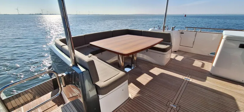 Bella Vita Yacht Photos Pics Azimut Magellano 66 yacht deck with seating and table, overlooking the ocean, 2020 model.