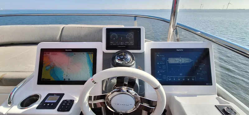Bella Vita Yacht Photos Pics Cockpit of 2020 Azimut Magellano 66 yacht with navigation screens and steering wheel.