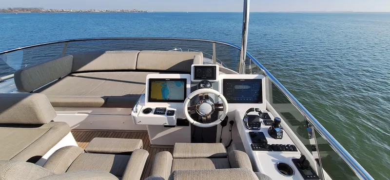 Bella Vita Yacht Photos Pics Luxurious 2020 Azimut Magellano 66 yacht helm with modern navigation systems, overlooking serene ocean.