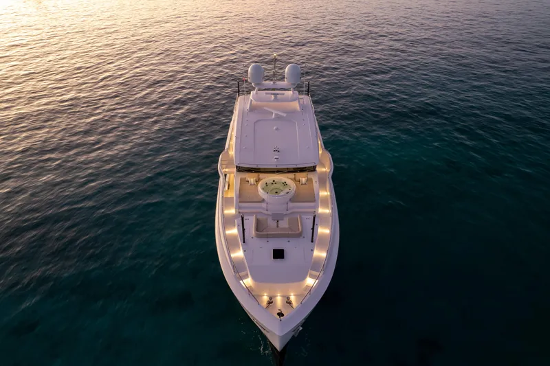 Rio Yacht Photos Pics Aerial view of 2023 Horizon FD90 yacht illuminated at sunset on calm ocean waters.