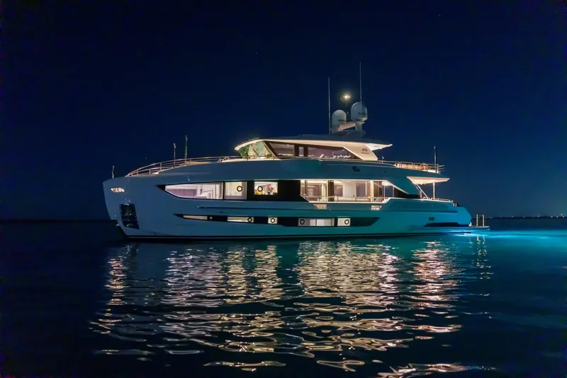 Rio Yacht Photos Pics Luxurious 2023 Horizon FD90 yacht illuminated at night on calm waters.