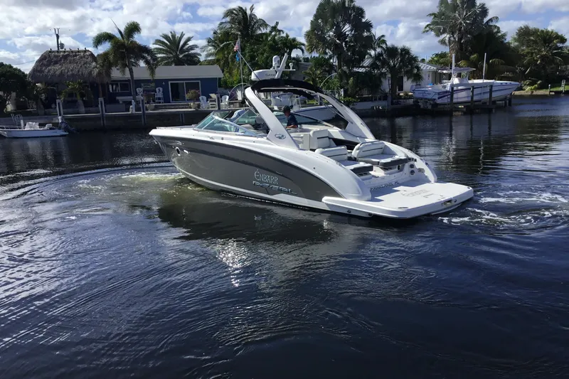 Enbarr Yacht Photos Pics 2017 Regal 3200 Bowrider cruising on a calm waterway with palm trees in the background.