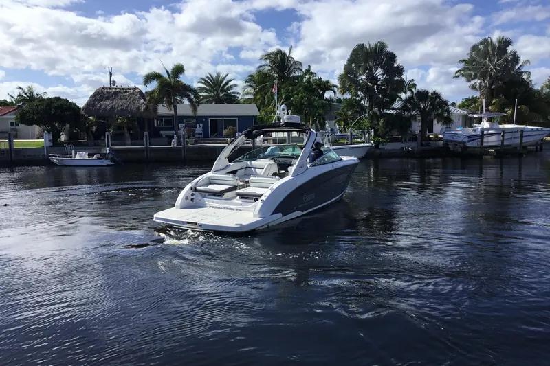 Enbarr Yacht Photos Pics 2017 Regal 3200 Bowrider cruising on a sunny day near waterfront homes.