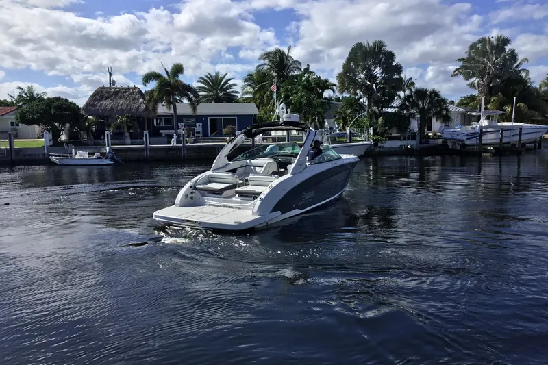 Enbarr Yacht Photos Pics 2017 Regal 3200 Bowrider cruising on a scenic waterway with palm trees.