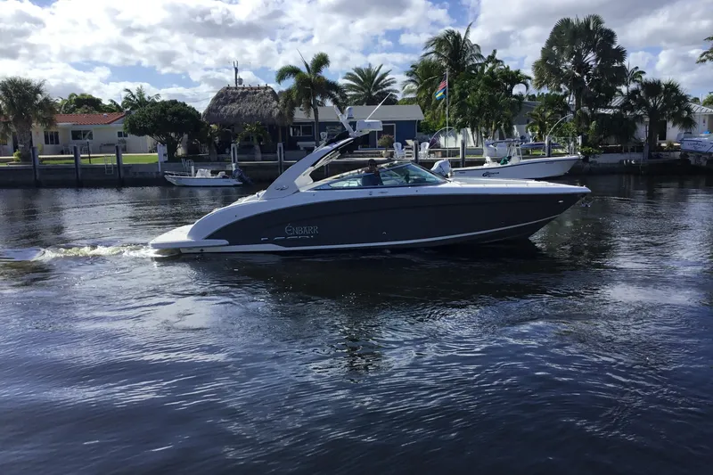 Enbarr Yacht Photos Pics 2017 Regal 3200 Bowrider cruising on a sunny day near waterfront homes.