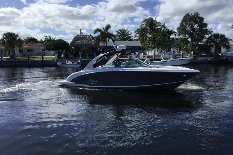 Enbarr Yacht Photos Pics 2017 Regal 3200 Bowrider cruising on a sunny waterfront with palm trees.