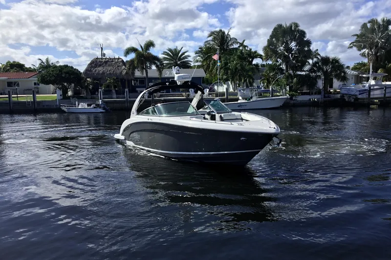 Enbarr Yacht Photos Pics 2017 Regal 3200 Bowrider cruising on a sunny day near waterfront homes.