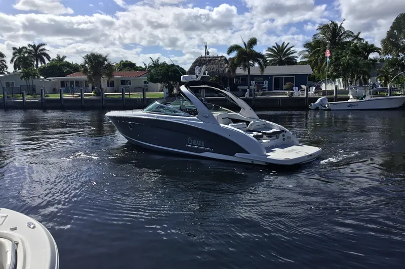 Enbarr Yacht Photos Pics 2017 Regal 3200 Bowrider cruising on a sunny day near waterfront homes.