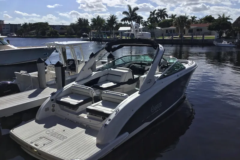 Enbarr Yacht Photos Pics 2017 Regal 3200 Bowrider boat docked by a scenic waterfront with palm trees.