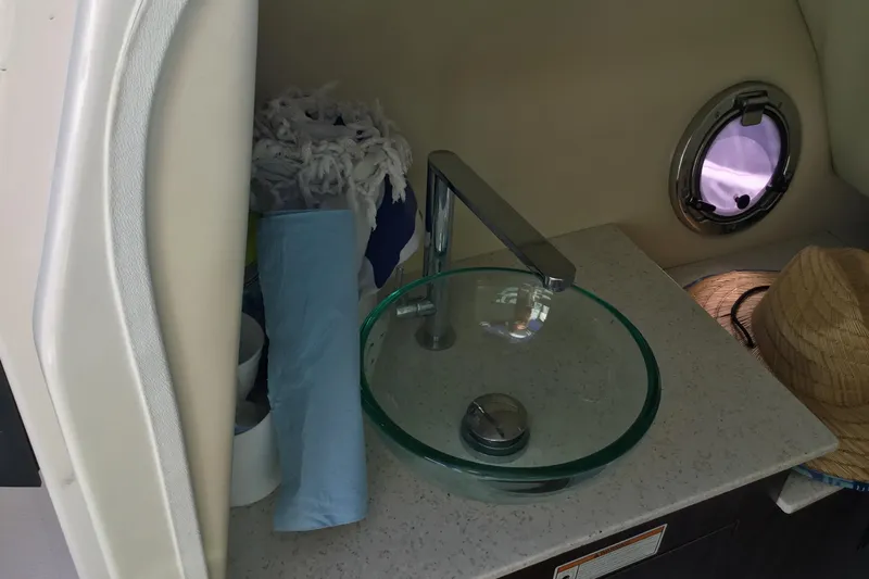 Enbarr Yacht Photos Pics 2017 Regal 3200 Bowrider interior with glass sink and porthole window.
