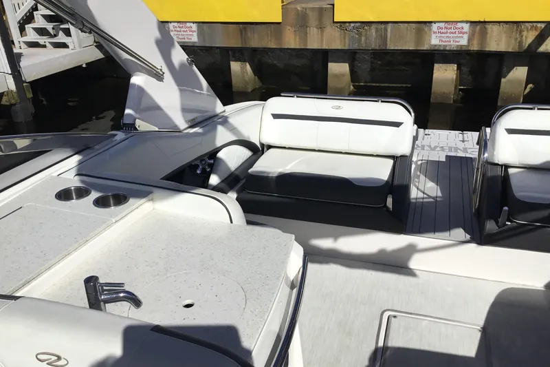 Enbarr Yacht Photos Pics 2017 Regal 3200 Bowrider interior with seating and kitchenette, docked near a yellow wall.
