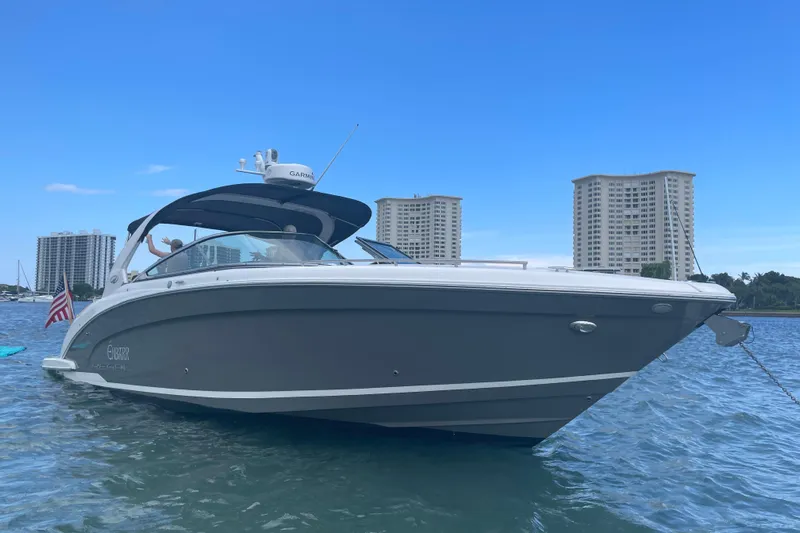 Enbarr Yacht Photos Pics 2017 Regal 3200 Bowrider boat on water with city skyline background.