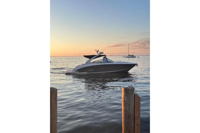 Enbarr Yacht Photos Pics 2017 Regal 3200 Bowrider cruising at sunset on calm waters.