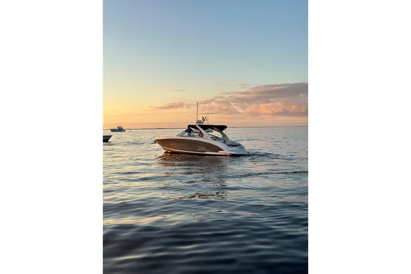 Enbarr Yacht Photos Pics 2017 Regal 3200 Bowrider cruising at sunset on calm waters.