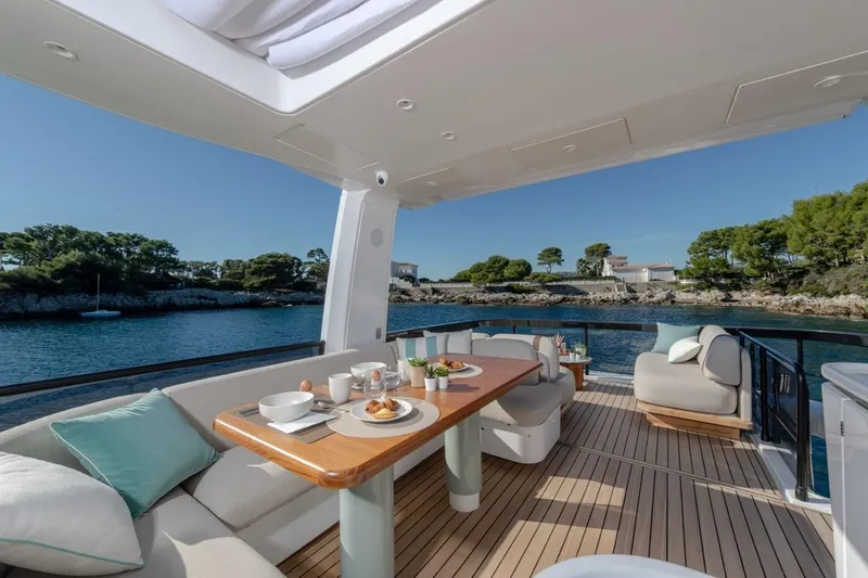  Yacht Photos Pics Luxurious 2025 Azimut Fly 62 yacht deck with elegant dining setup and scenic ocean view.